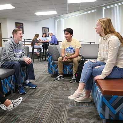 Students sitting on couches talking to each other